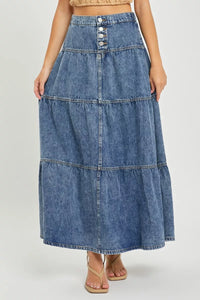 Long denim skirt worn by a person on a white background