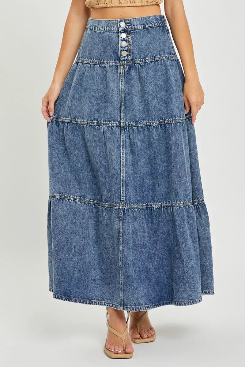 Long denim skirt worn by a person on a white background