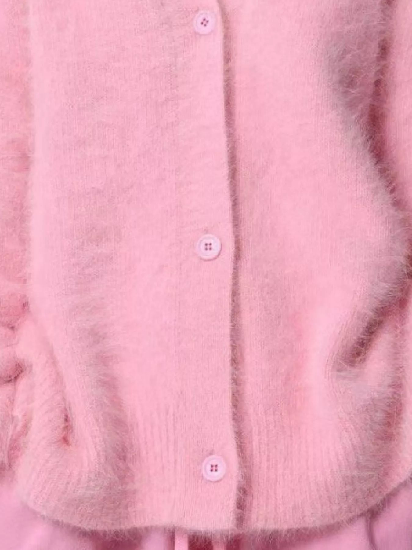 Close-up of a pink textured fabric with buttons