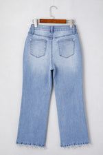 Light blue jeans on a hanger against a white background