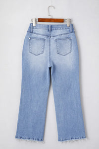 Light blue jeans on a hanger against a white background