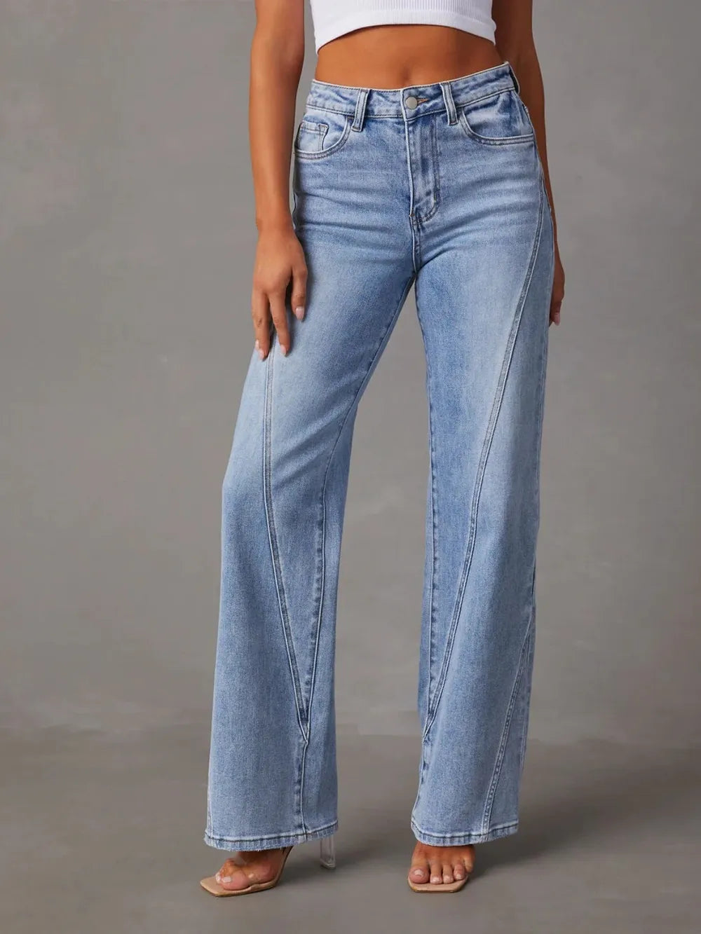Light blue jeans worn by a person on a gray background