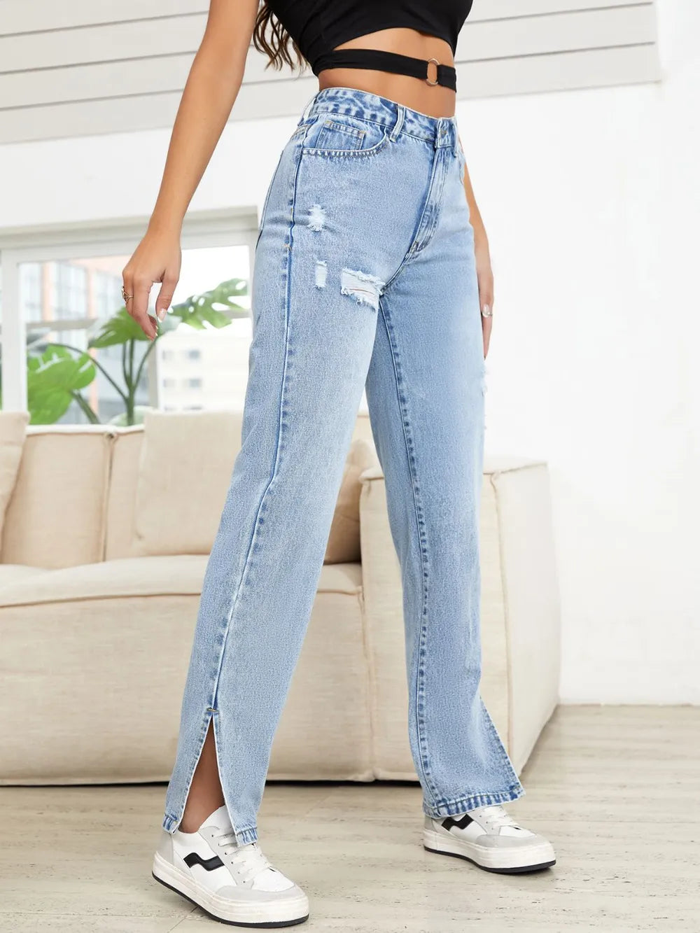 Person wearing light blue jeans with a white background