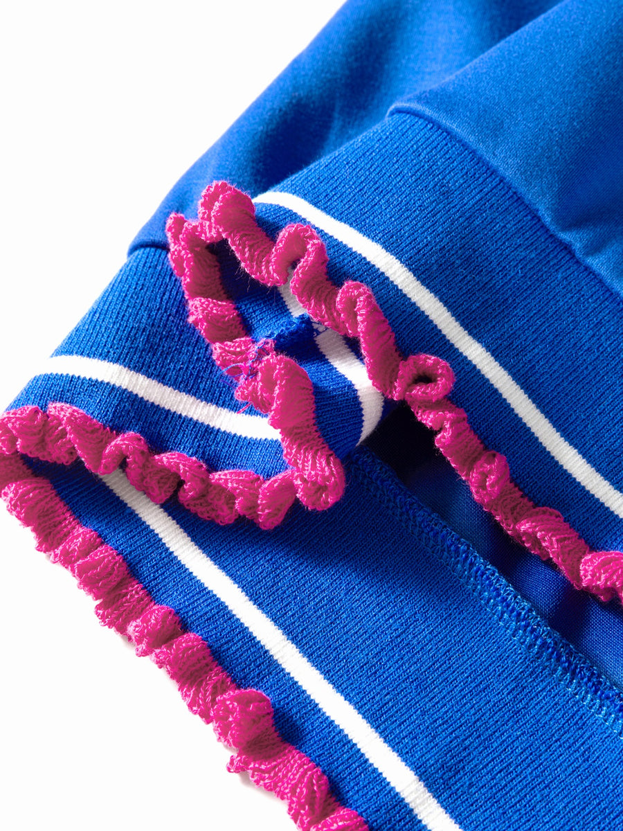 Close-up of blue fabric with pink and white trim on a white background