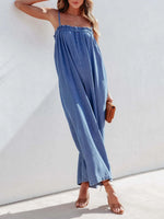 Woman wearing a blue jumpsuit against a white background