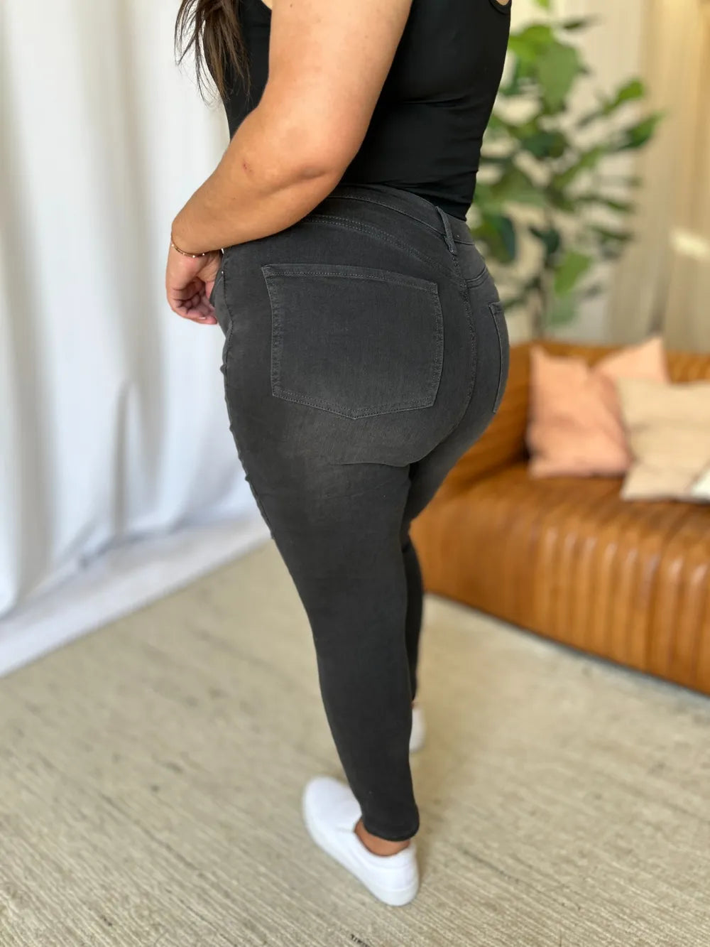 Person wearing black jogger pants in a living room setting
