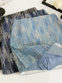 Two blue patterned rugs on a white surface