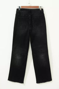 Black jeans on a hanger against a white background
