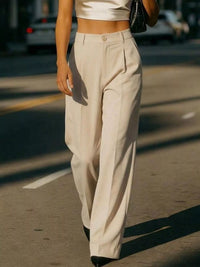 Person wearing beige high-waisted pants on a street.