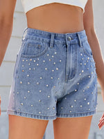 Denim shorts with rhinestone embellishments on a neutral background