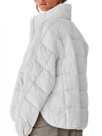 Light gray quilted jacket worn by a person on a white background