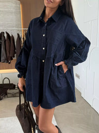 Woman wearing a navy blue dress in an indoor setting