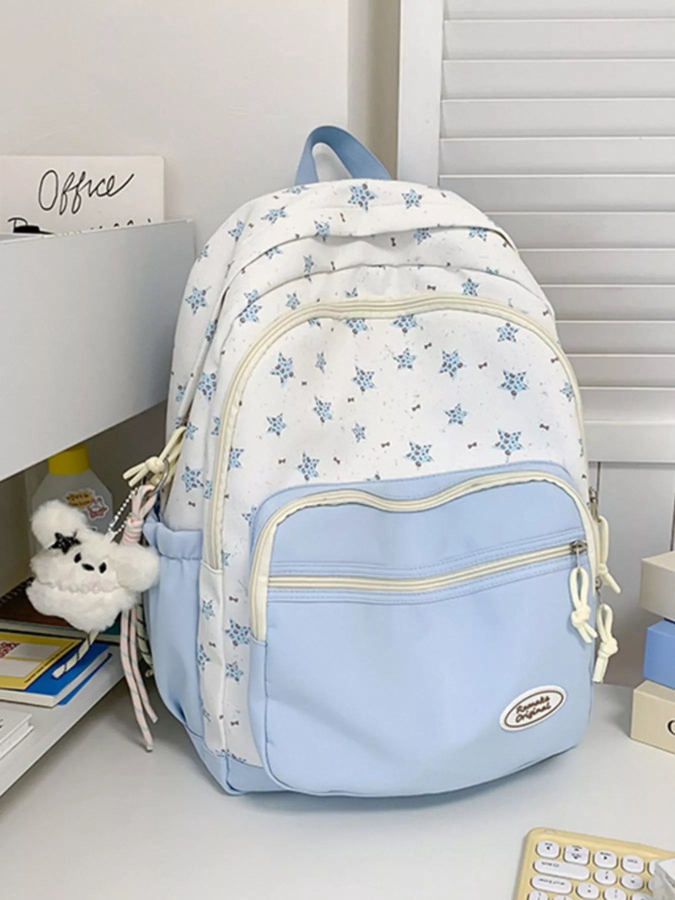 Light blue and white floral-patterned backpack on a desk