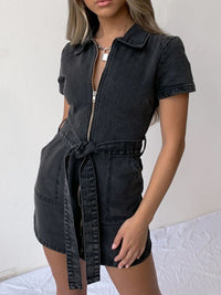 Black denim dress with a belt worn by a person on a white background