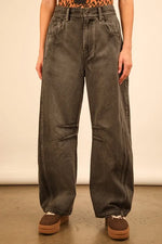 Person wearing wide-leg jeans with a plain background