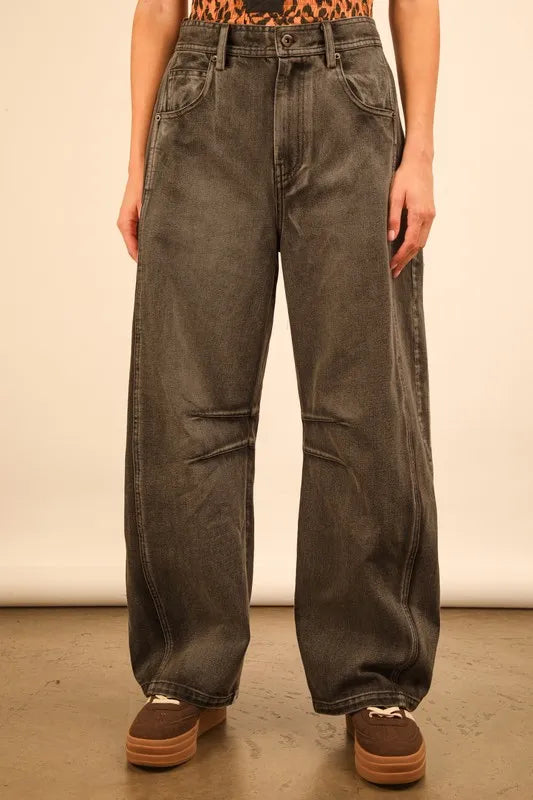 Person wearing wide-leg jeans with a plain background