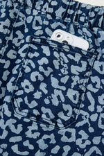 Navy blue shorts with a light blue leopard print pattern, showing a pocket.