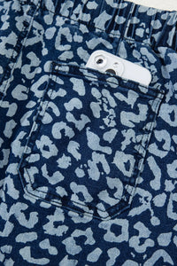 Navy blue shorts with a light blue leopard print pattern, showing a pocket.