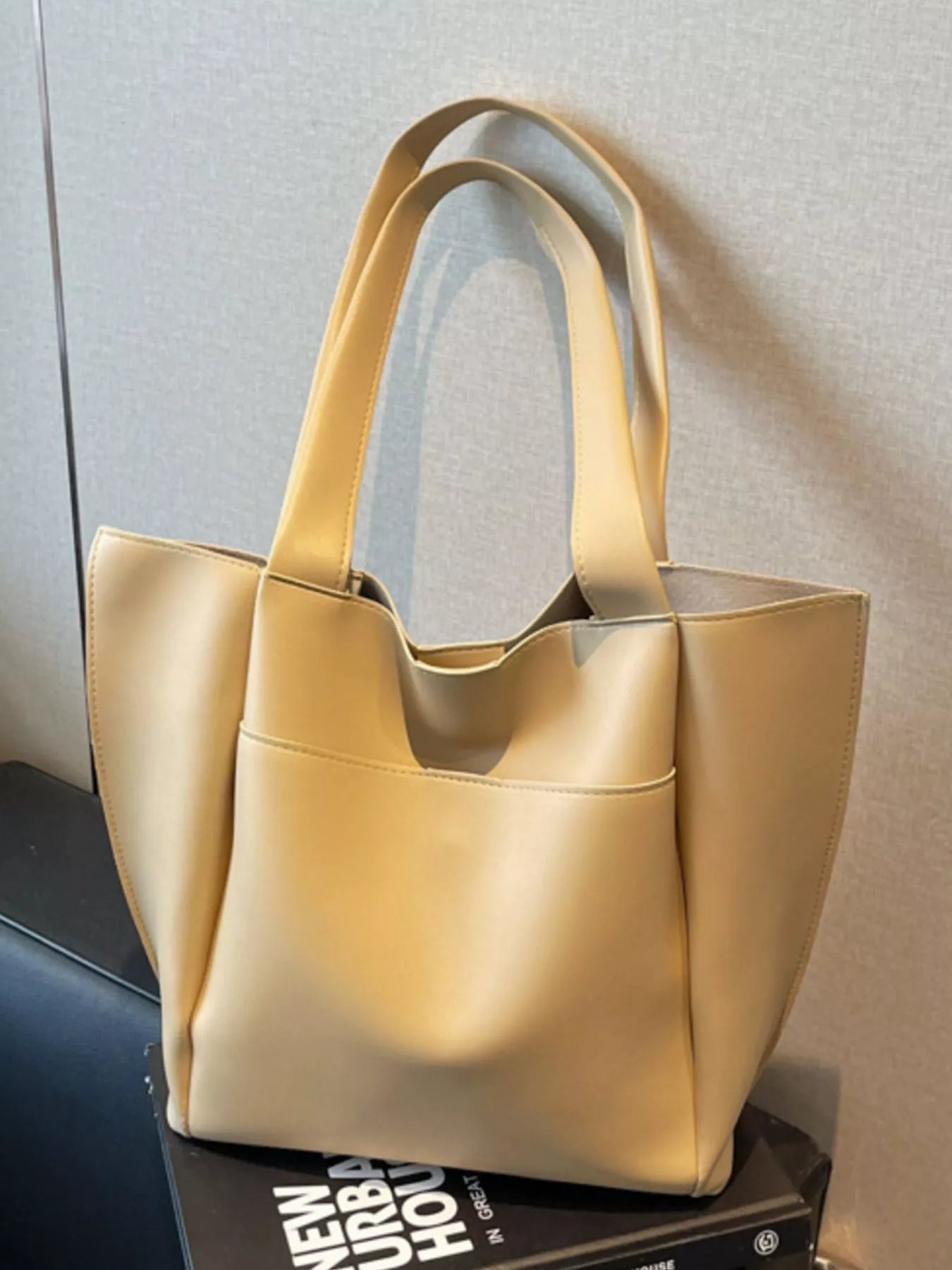 Yellow tote bag on a surface with a neutral background
