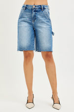 Blue denim shorts worn by a person on a white background