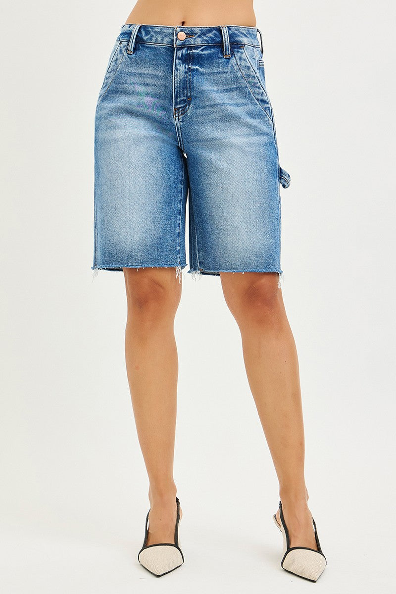 Blue denim shorts worn by a person on a white background
