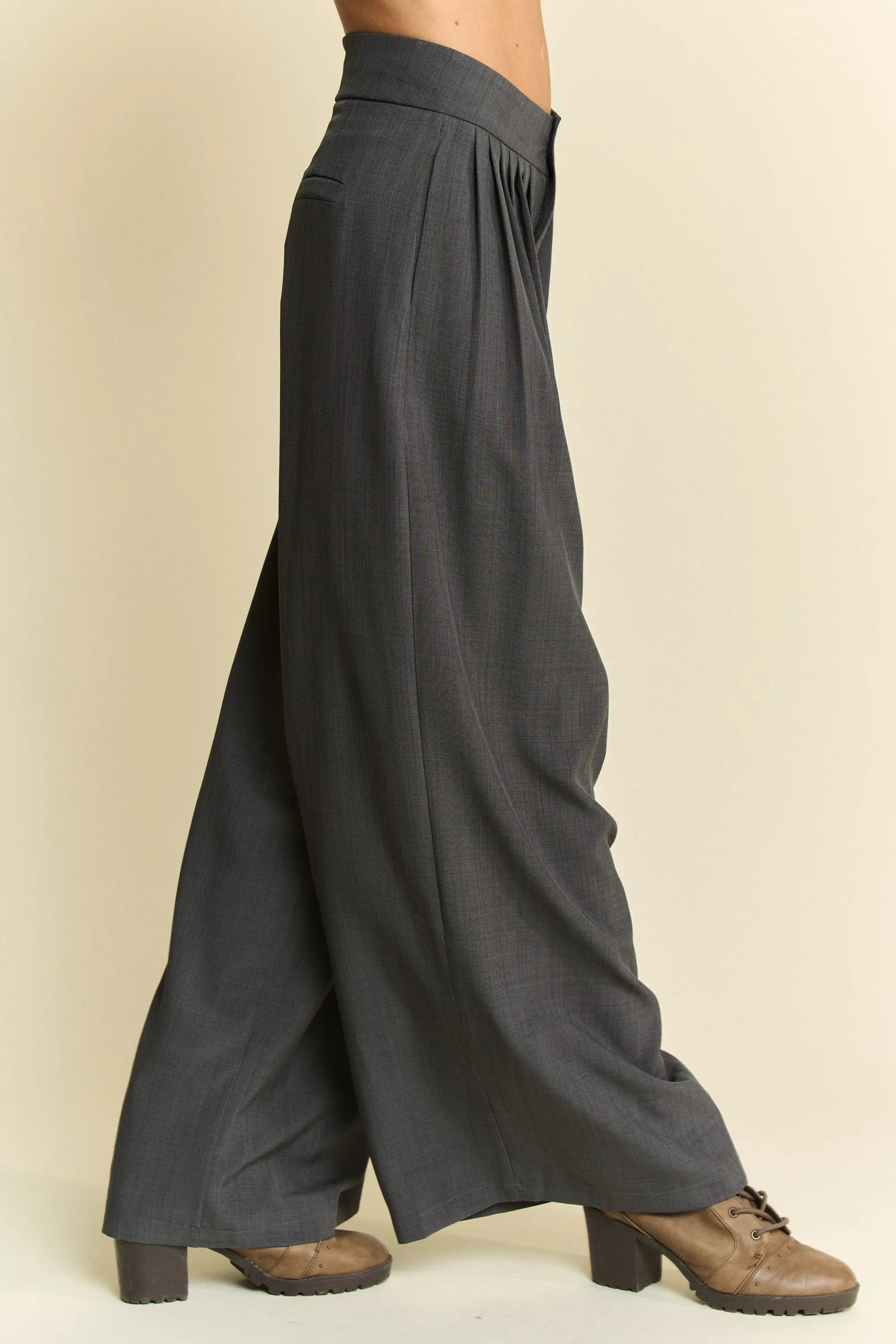 Dark gray wide-leg pants worn by a person on a beige background