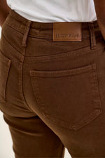 Brown pants with a visible brand label on a neutral background