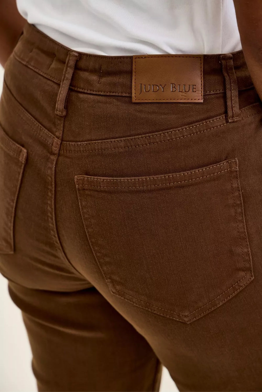 Brown pants with a visible brand label on a neutral background
