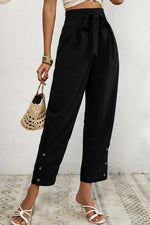 Person wearing black wide-leg pants with a white background