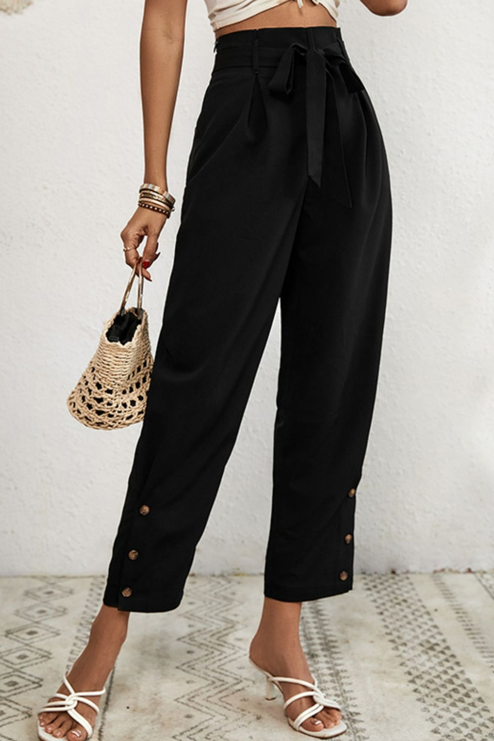 Person wearing black wide-leg pants with a white background