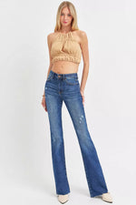 Woman wearing a beige top and blue jeans on a white background