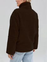 Person wearing a brown jacket on a plain background