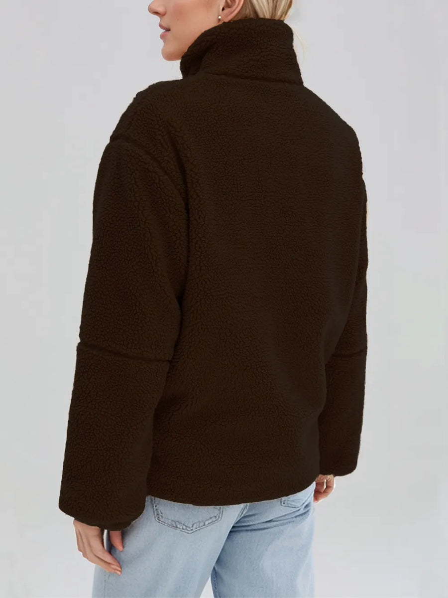 Person wearing a brown jacket on a plain background