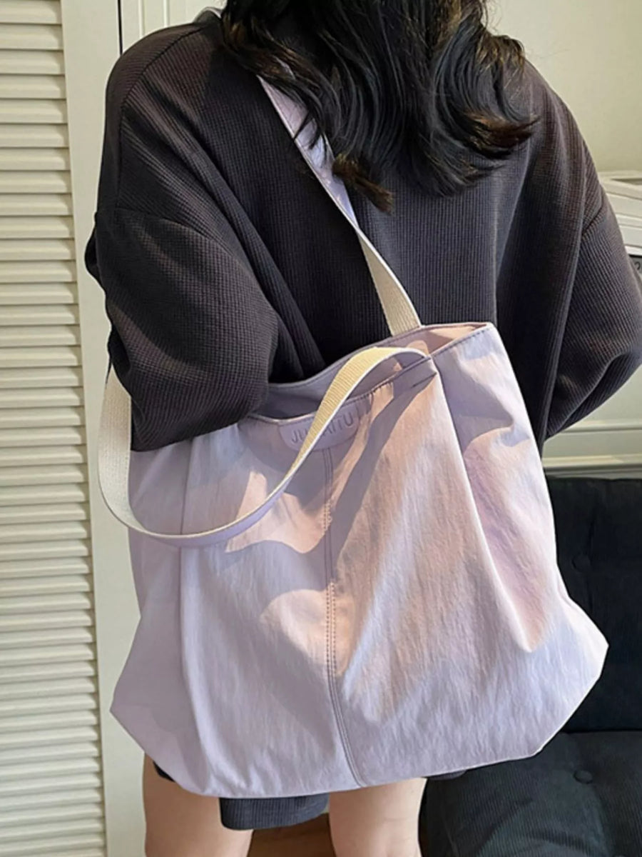 Person holding a transparent tote bag with a reflective surface.