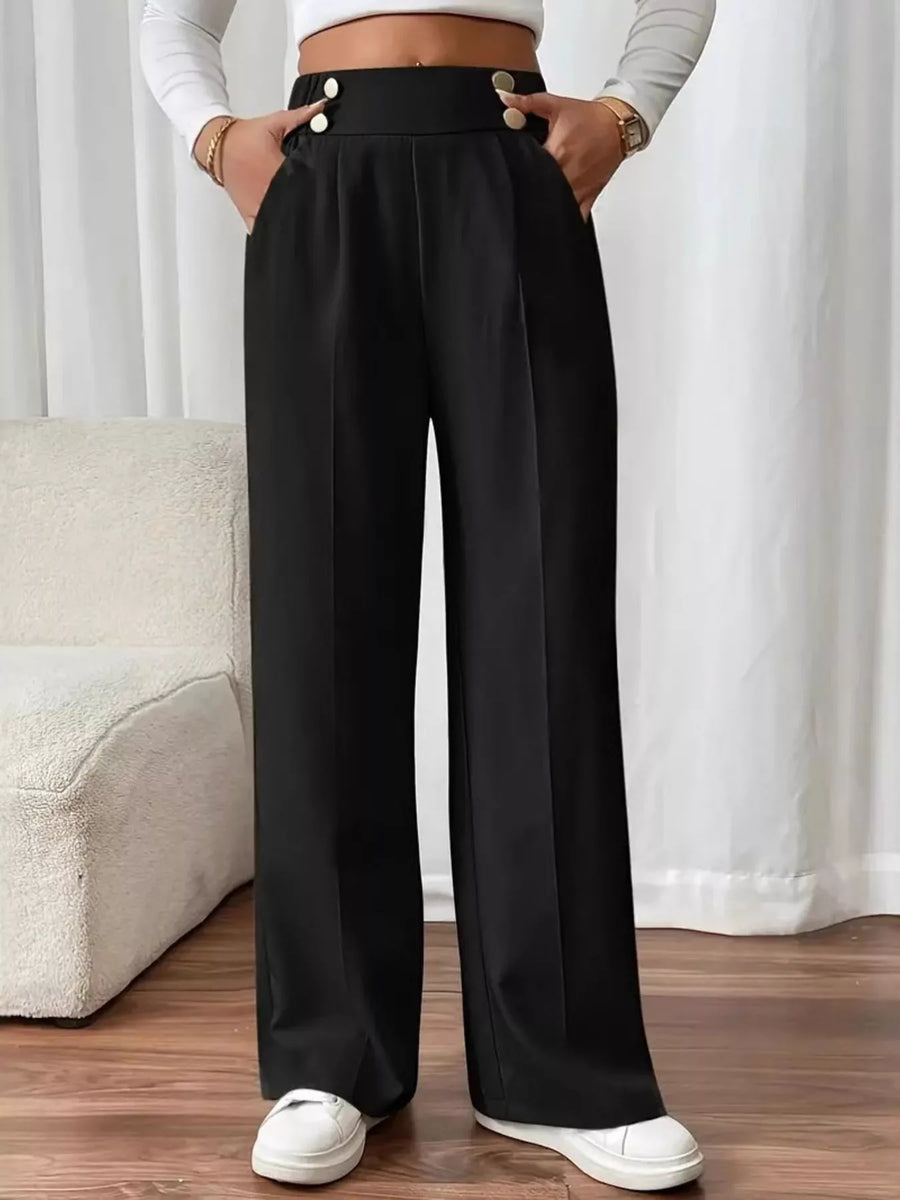 Person wearing black wide-leg pants with a white background