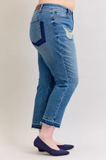 Blue jeans worn by a person on a plain background