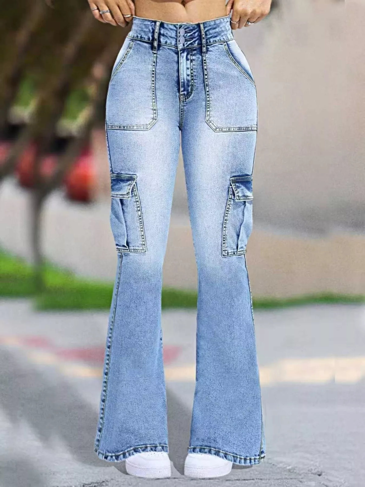 Light blue high-waisted flare jeans with cargo pockets, shown on a model in an outdoor setting.