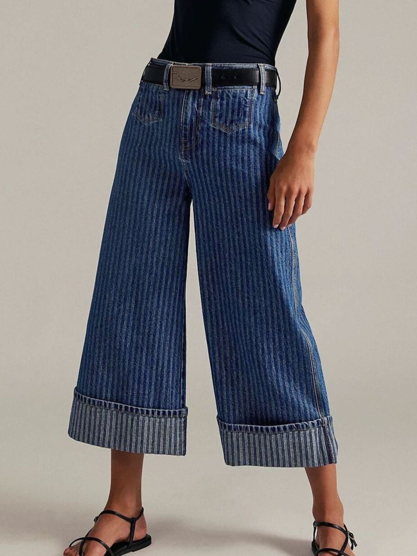 Wide-leg blue jeans worn by a person on a neutral background