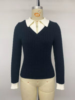 A dark navy blue cable-knit long-sleeve sweater with a cream-colored collar and matching ribbed cuffs, displayed on a beige mannequin torso against a light gray background.