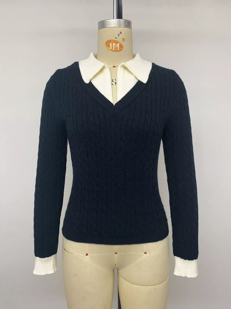 A dark navy blue cable-knit long-sleeve sweater with a cream-colored collar and matching ribbed cuffs, displayed on a beige mannequin torso against a light gray background.