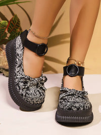 Black and white patterned shoes with chunky black sole on a neutral background