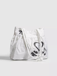 White tote bag with black patterns on a light gray background
