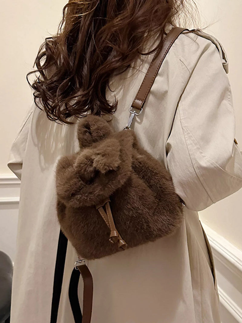 Person wearing a fluffy brown backpack with a neutral background