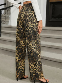 Person wearing leopard print pants standing on a staircase.