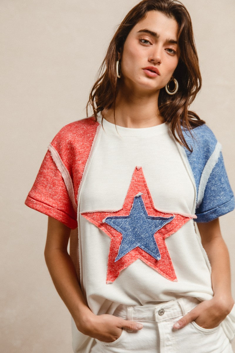 Woman wearing a white t-shirt with a red and blue star design on a beige background