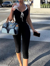 Woman in black outfit with denim handbag crossing street