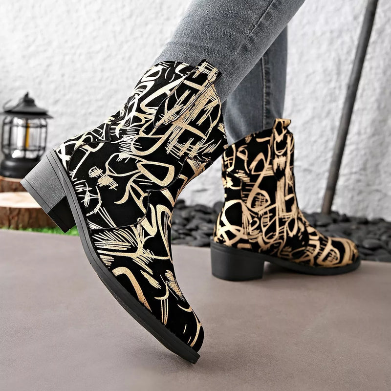 Black and gold patterned boots worn with gray pants on a neutral background