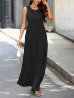 Woman wearing a black sleeveless dress walking on a street.