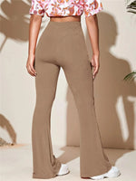 Person wearing brown flared pants and a floral top on a beige background