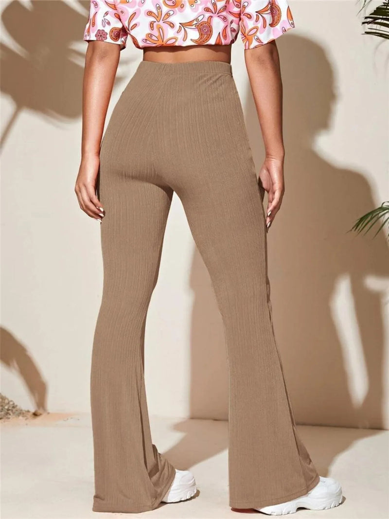 Person wearing brown flared pants and a floral top on a beige background